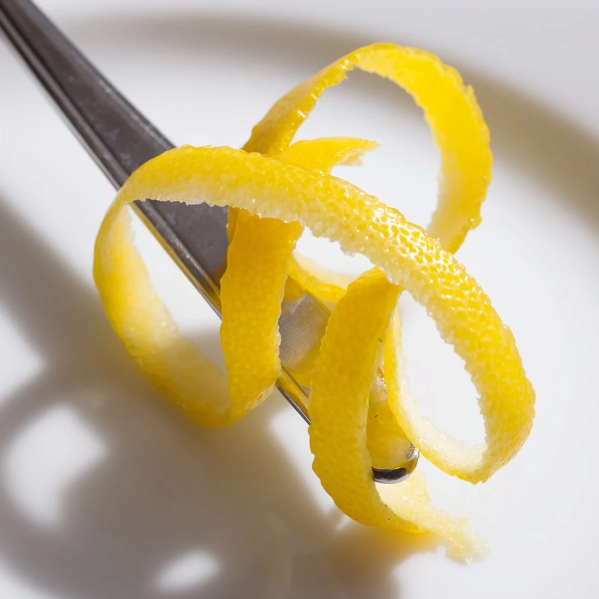 Présentation d'un twist aromatique de citron, donnant un parfum lumineux à votre boisson.