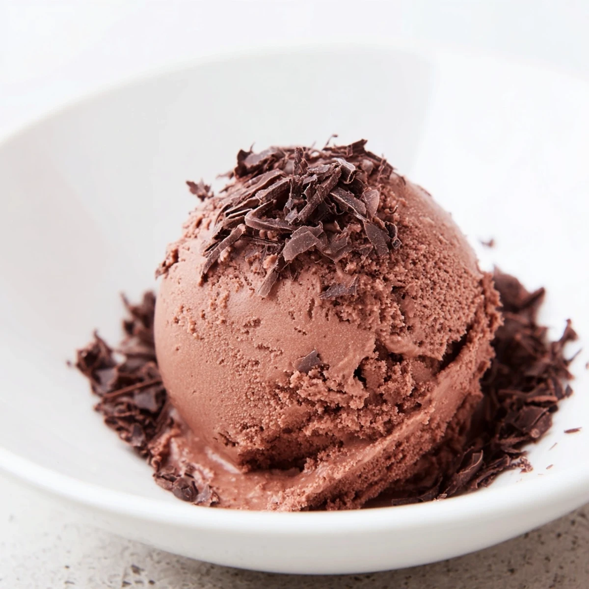 A rich, swirled scoop of homemade chocolate ice cream, ready to enjoy this dessert.