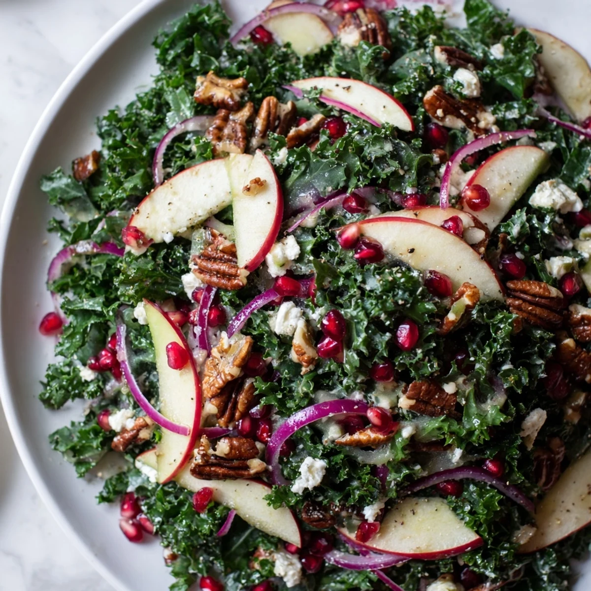 A fresh Winter Kale Salad with pomegranate, bursting with ruby seeds and toasted pecans.