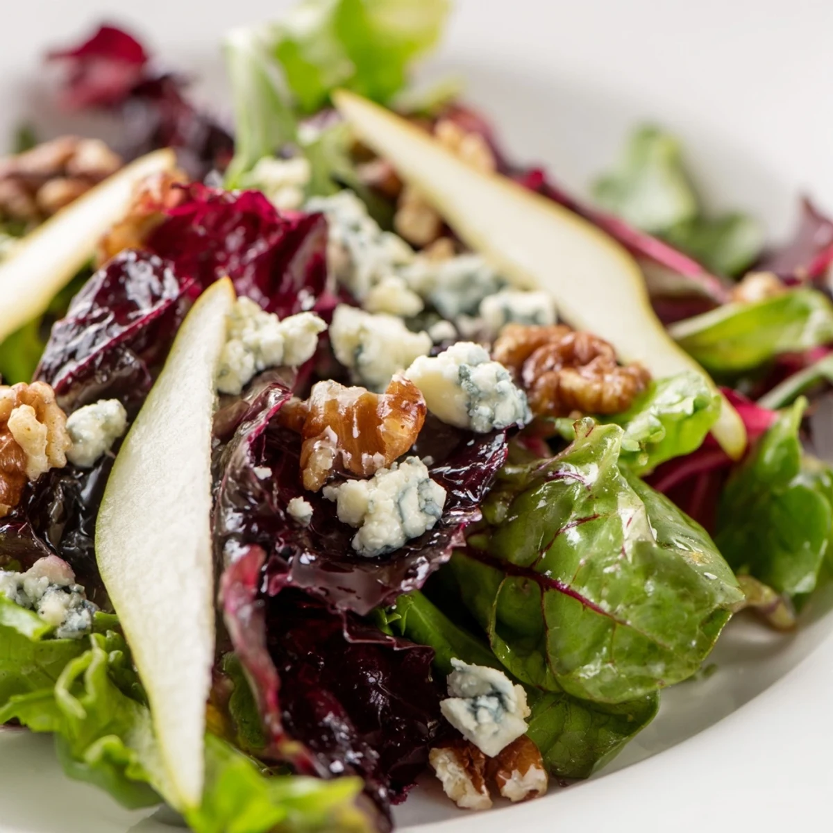 Une salade d'Hiver aux Poires et Noix Grillées, fromage de chèvre effrité et noix sucrées sur un plat de crudités frais.
