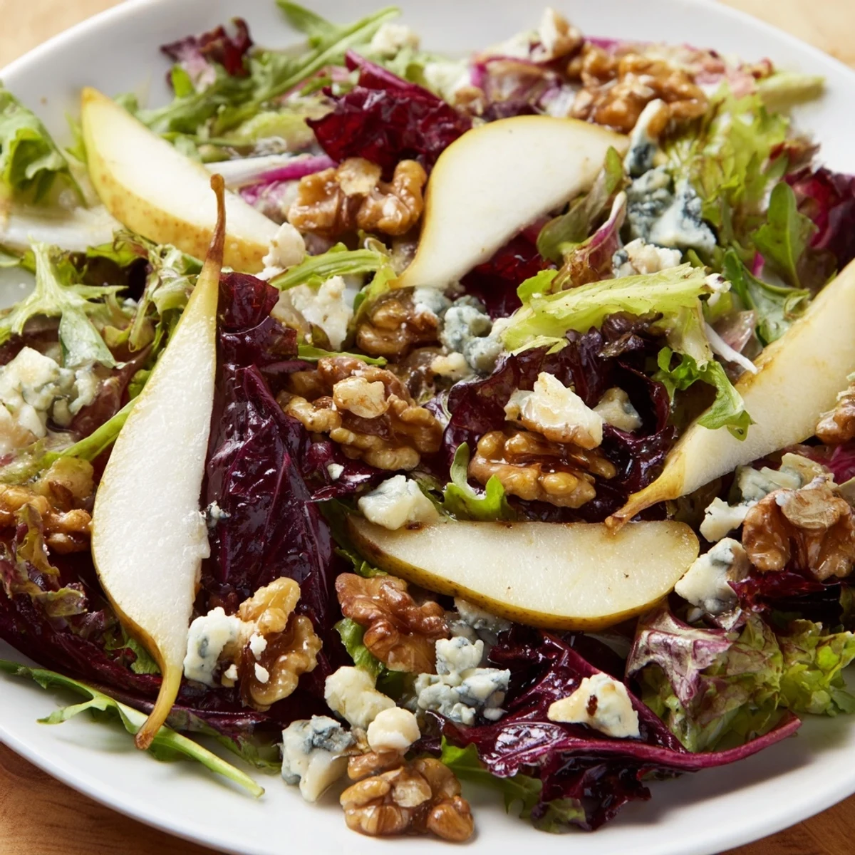 La salade d'Hiver aux Poires et Noix Grillées, tranches de poire juteuse et mélange de crudités avec vinaigrette piquante.