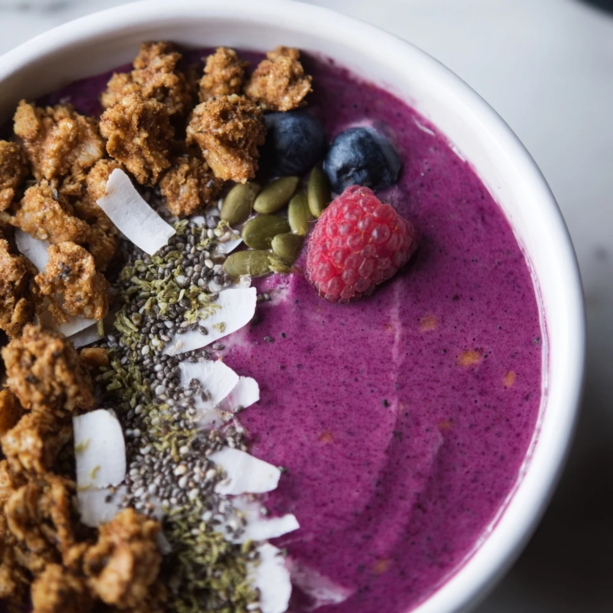 Smoothie Bowl aux Baies Hivernales avec Chia et Graines de Chanvre, parfaitement crémeux et garni de fruits frais.