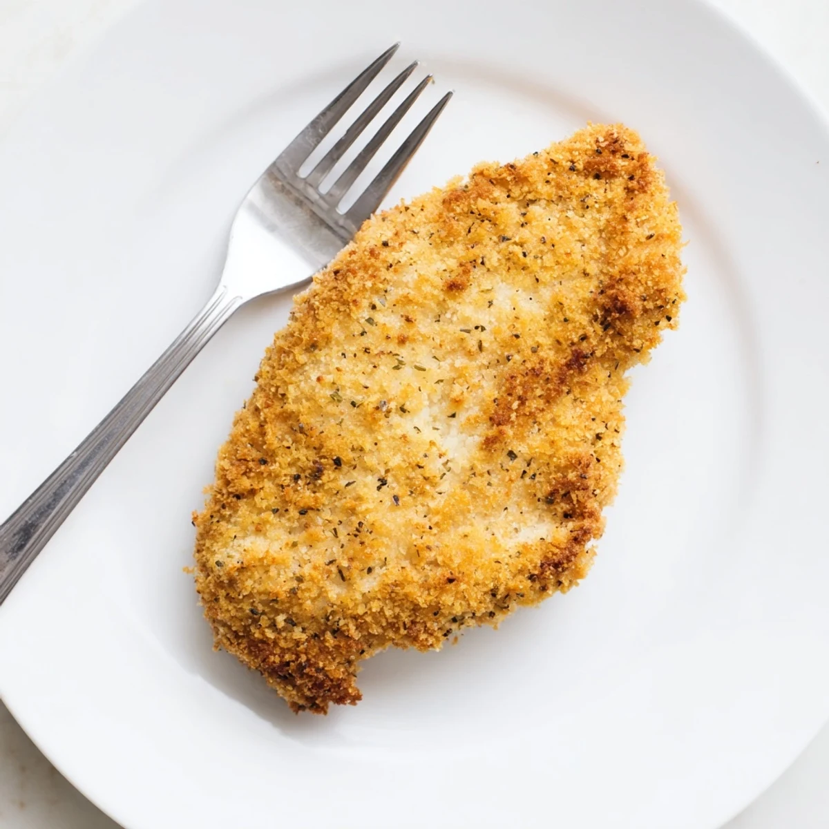 Saveurs réconfortantes de Côtelette de Poulet Supper croustillante, avec des détails de panure à l'origan et de la viande tendre et juteuse.