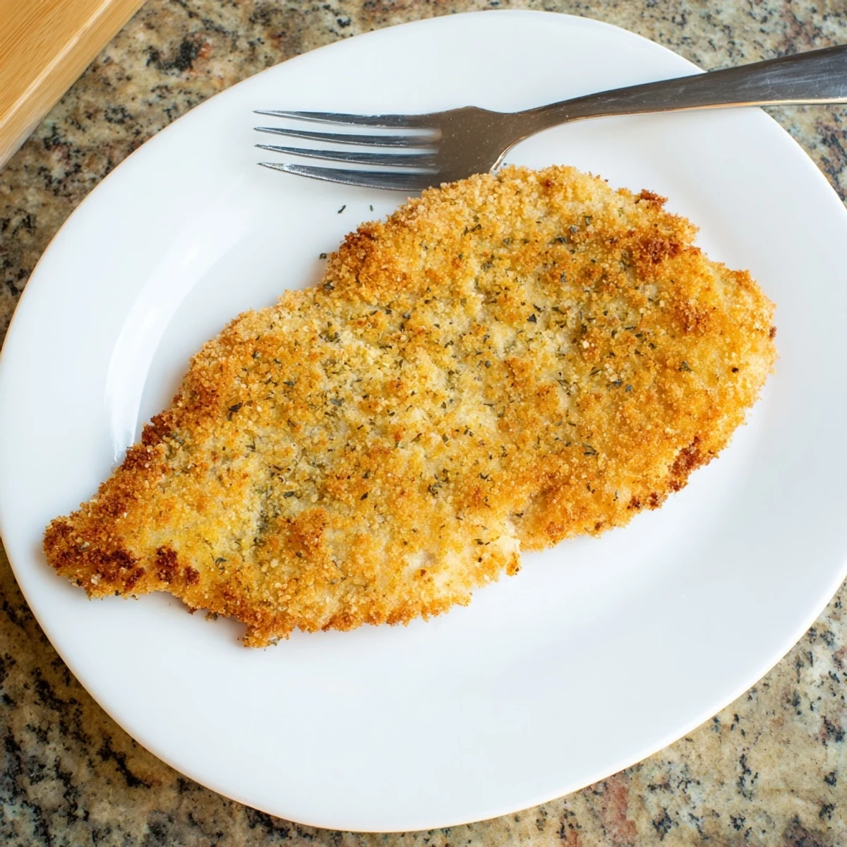 Des tranches dorées de Côtelette de Poulet Supper, encore fumantes, accompagnées d'un filet de citron et d'une salade verte croquante.