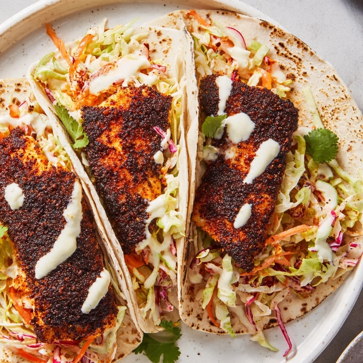 Golden fish nestled in warm tortillas with crunchy slaw for Louisiana Blackened Fish Tacos.