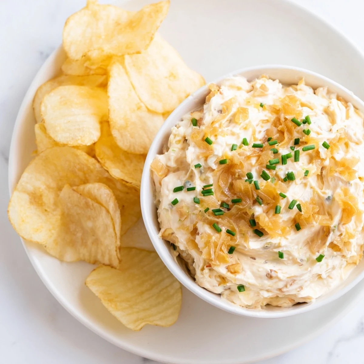 A generous scoop of onion dip surrounded by crunchy potato chips, perfect for game day or parties.