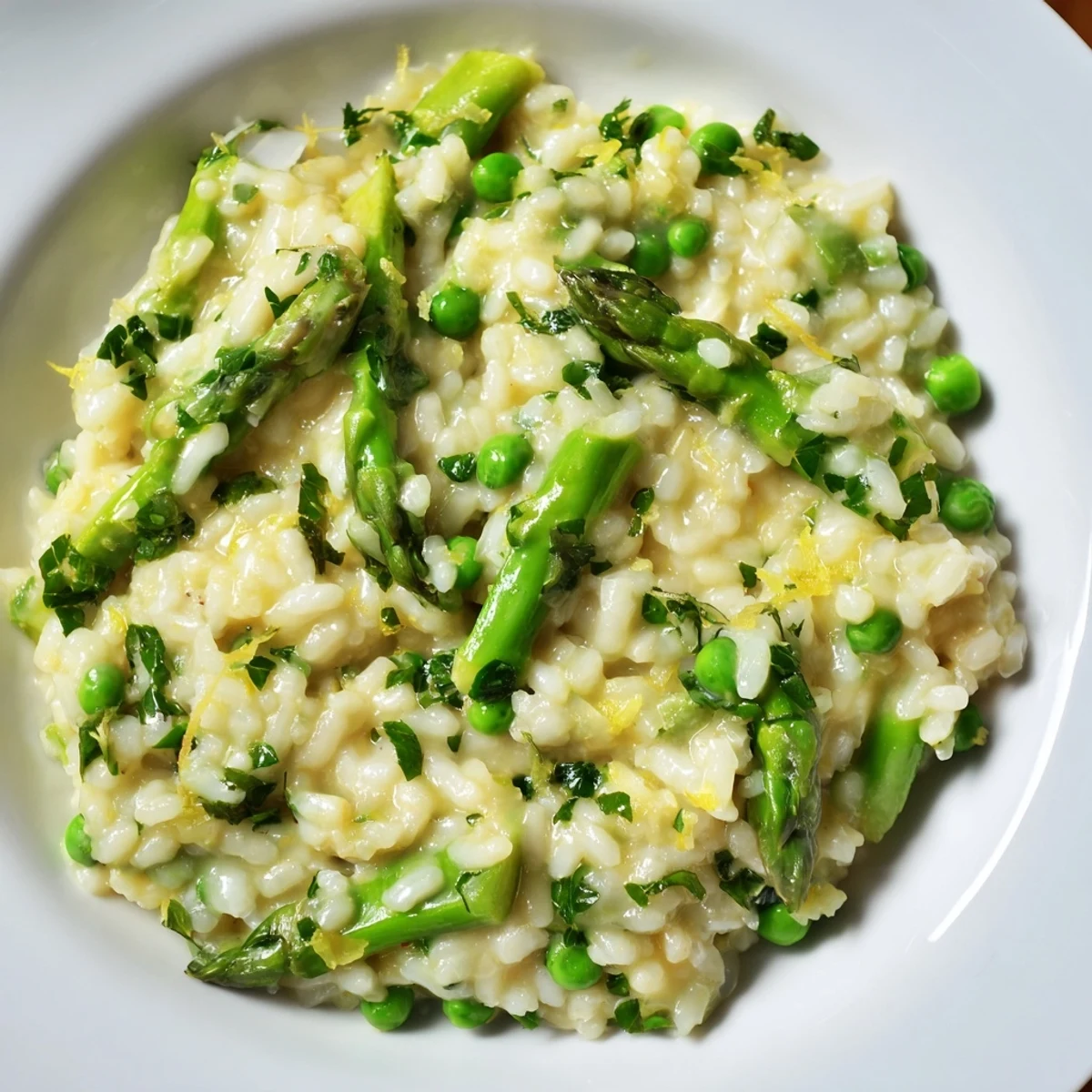 Un bol de Spring Pea and Asparagus Risotto encore fumant, parsemé de persil frais et de zeste de citron pour une touche finale.