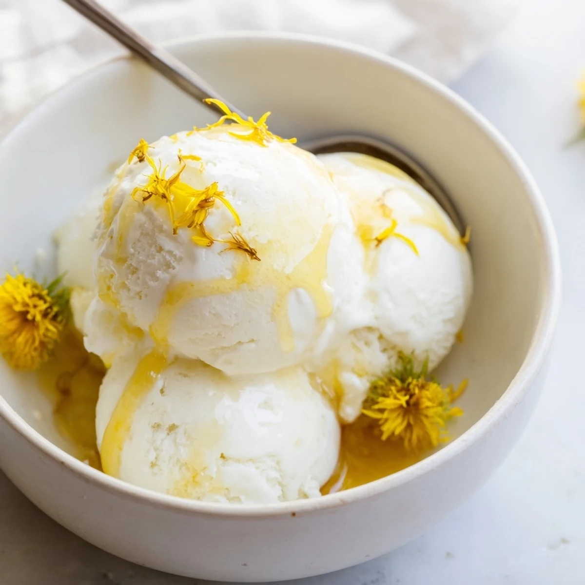 Creamy homemade Dandelion Honey Ice Cream churned to silky perfection in elegant glass serving bowl