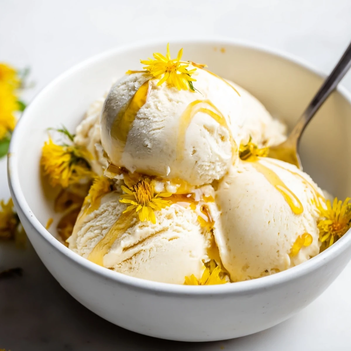 Spring dessert featuring Dandelion Honey Ice Cream topped with fresh edible flowers and sweet honey swirl