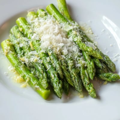Asperges citronnées à l'ail, saupoudrées de Parmesan, parfaites pour un accompagnement printanier.