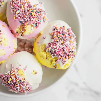 Les cake pops en forme d'œufs de Pâques, couverts de chocolat irisé et de sprinkles festifs, prêts à être dégustés.