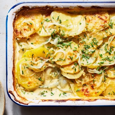 Tender sliced potatoes layered with melted Gruyère cheese in bubbling gratin dish